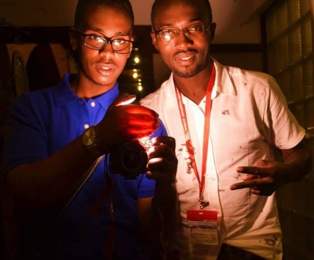 Osman Aldidiri (right) and Moumini Niaoné, several years ago in Tanzania, holding a candle.